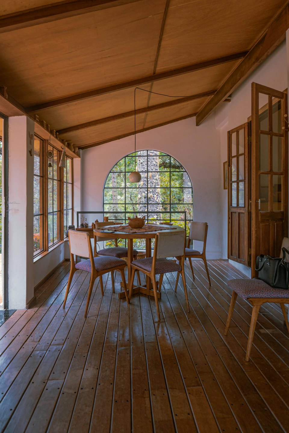 Indoor dining area with round table and chairs, opening to outdoors.